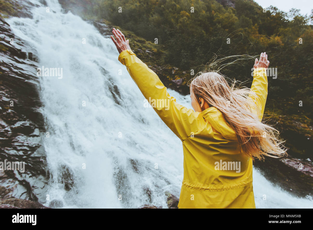 Femme voyageur soulevées mains profitant du paysage cascade voyage seul dans l'aventure sauvage vie de l'harmonie avec la nature émotionnelle concept expre Banque D'Images