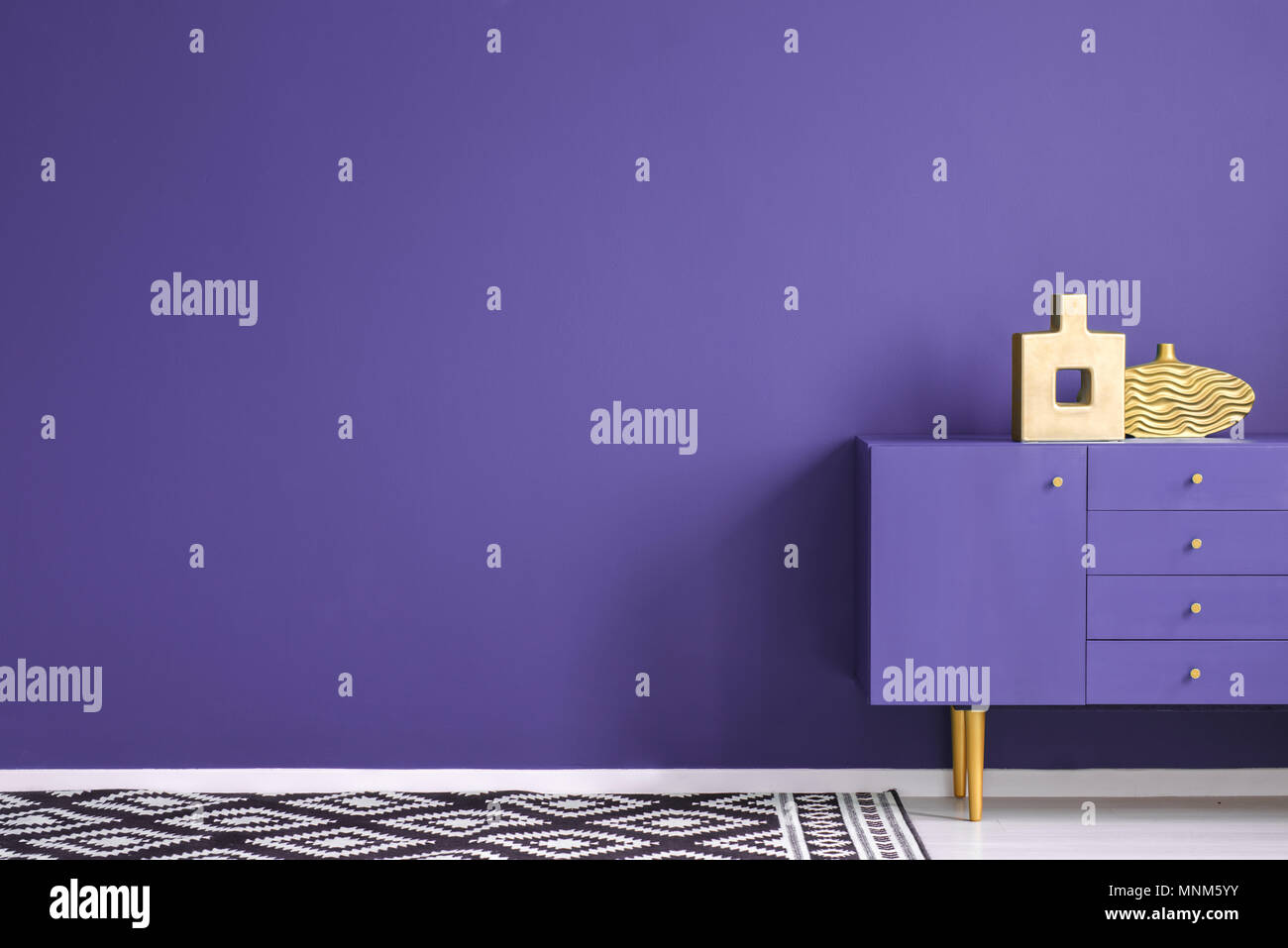 Des vases d'or sur violet dans une antichambre du cabinet intérieur avec des tapis à motifs et de copier l'espace sur mur pourpre Banque D'Images