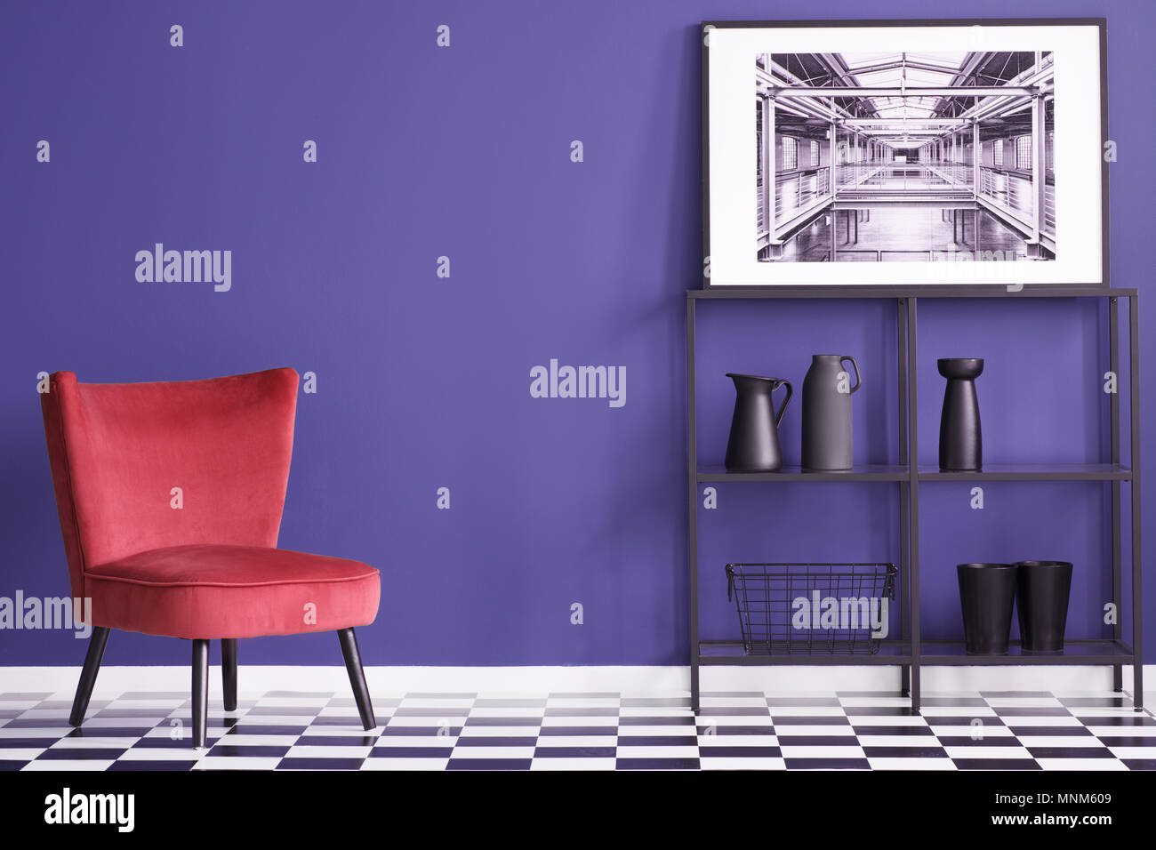 Vases noirs sur les étagères à proximité rouge suède président au sol en damier en violet télévision intérieur avec poster Banque D'Images