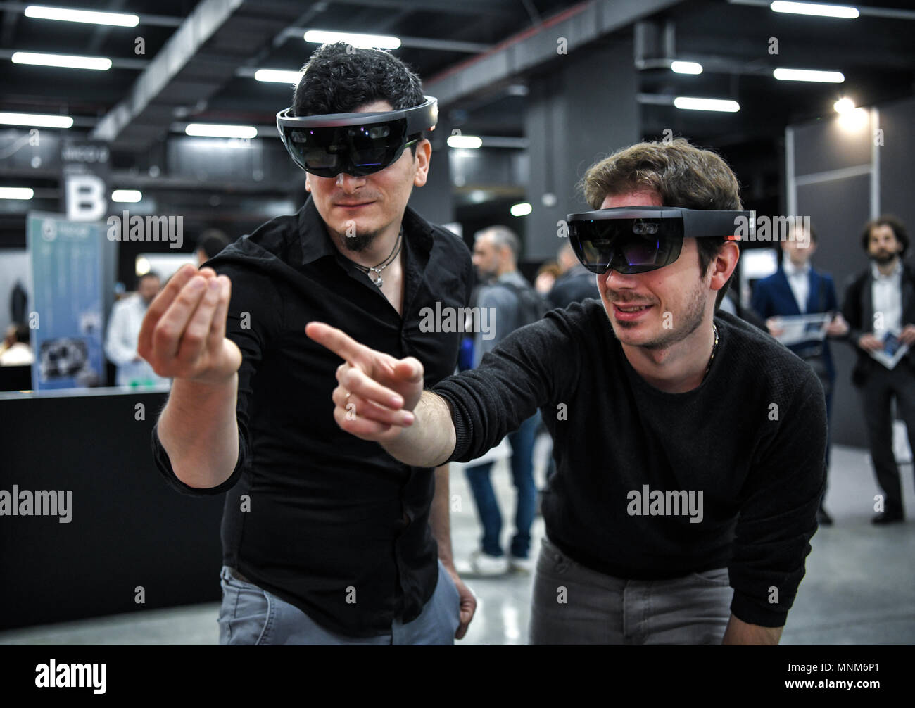 Milan, Italie - 17 mai 2018 : Deux jeunes hommes portant des casques de réalité virtuelle VR gesticuler et interagir ensemble au cours de la de la technologie en 2018. Banque D'Images