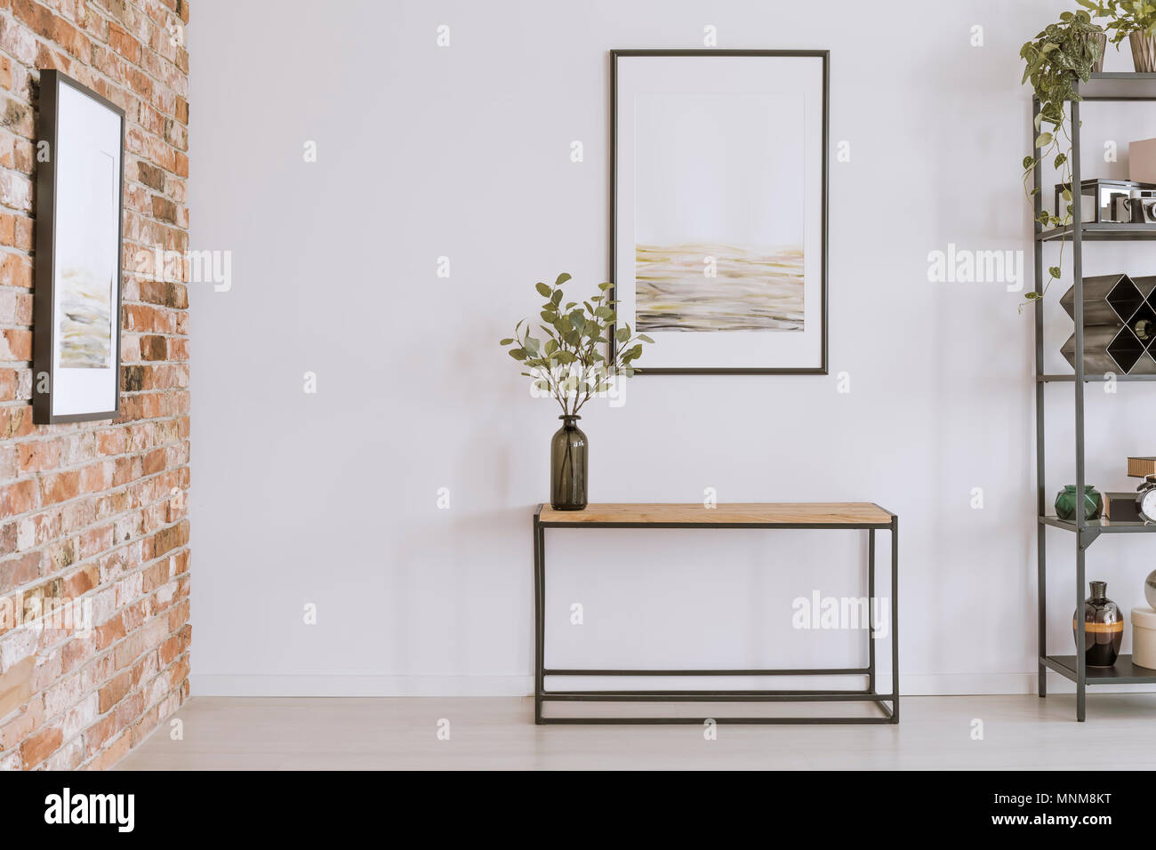 Peinture simple en bois au-dessus de table console avec des brindilles dans un vase de verre in modern living room interior Banque D'Images