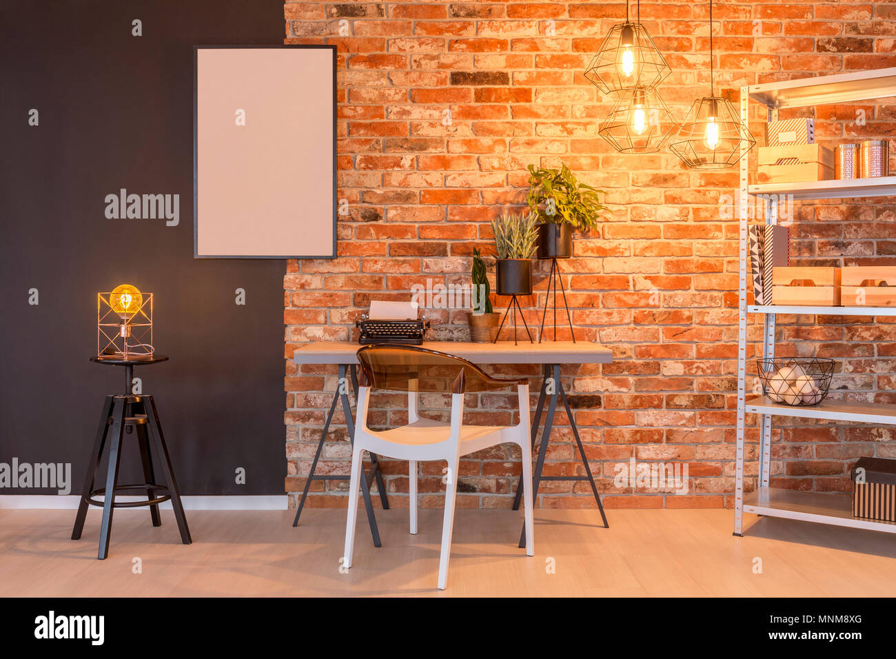 Loft avec mur de brique, bureau, chaise, lampe, tableau, les plantes Banque D'Images
