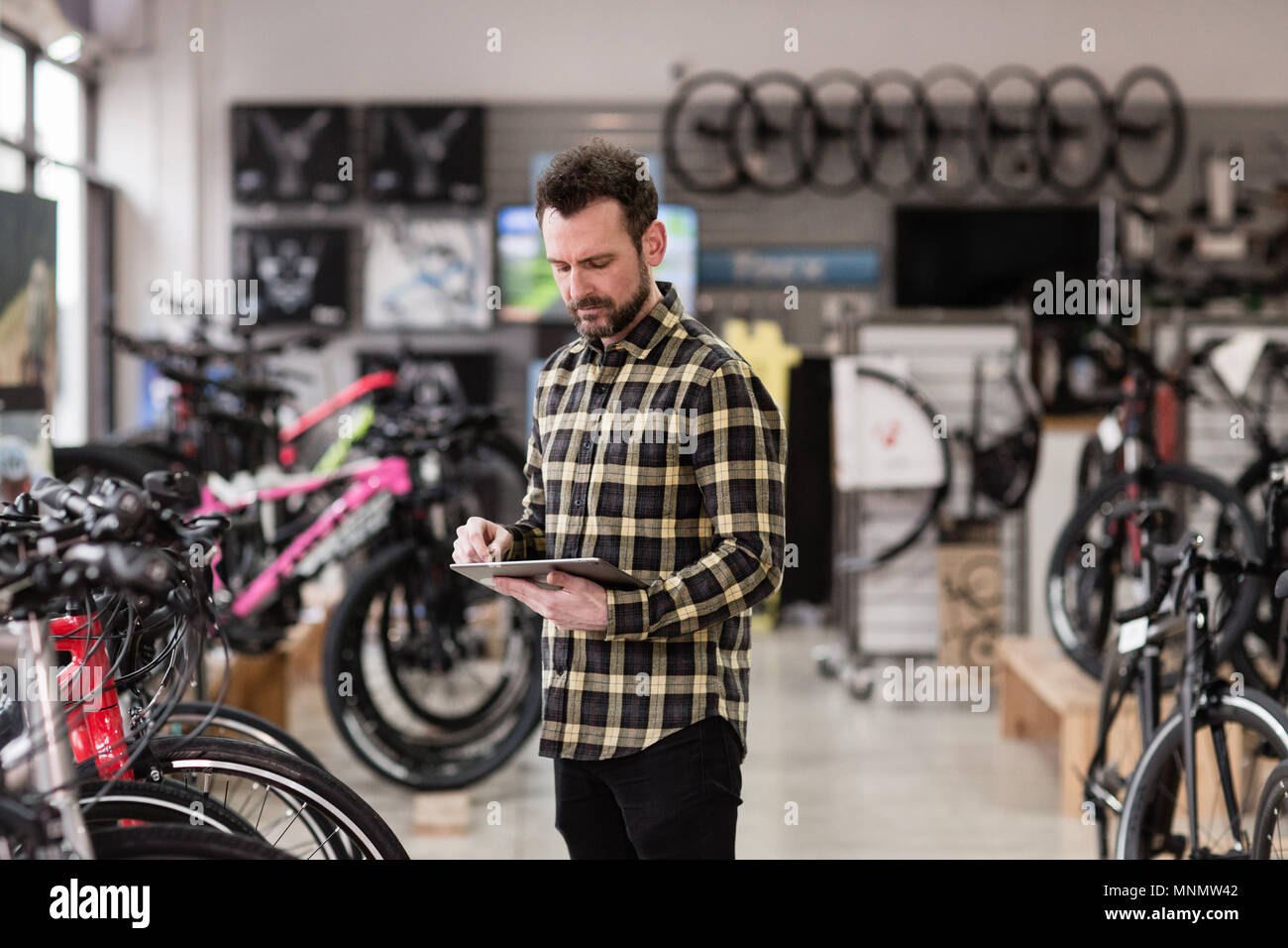 Propriétaire de petite entreprise à l'aide de tablette numérique dans un magasin de cycle Banque D'Images