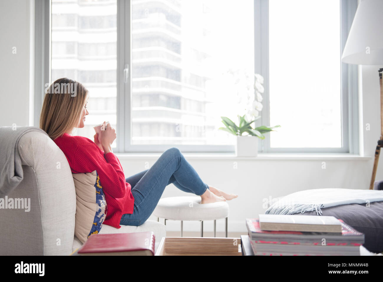 Young woman relaxing in living room Banque D'Images