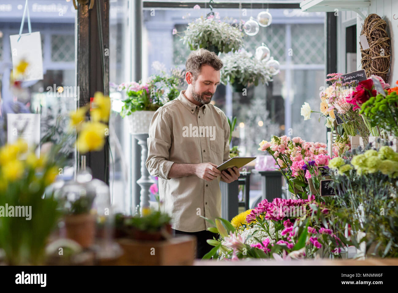 Propriétaire de petite entreprise using digital tablet in un fleuriste Banque D'Images