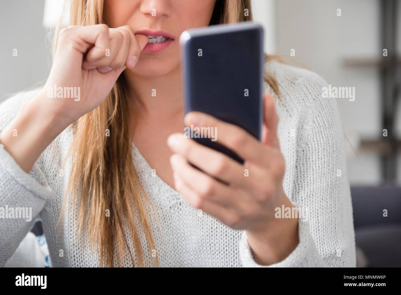 Jeune femme nerveux à l'aide de smart phone Banque D'Images Jeune femme nerveux à l'aide de smart phone Banque D'Images