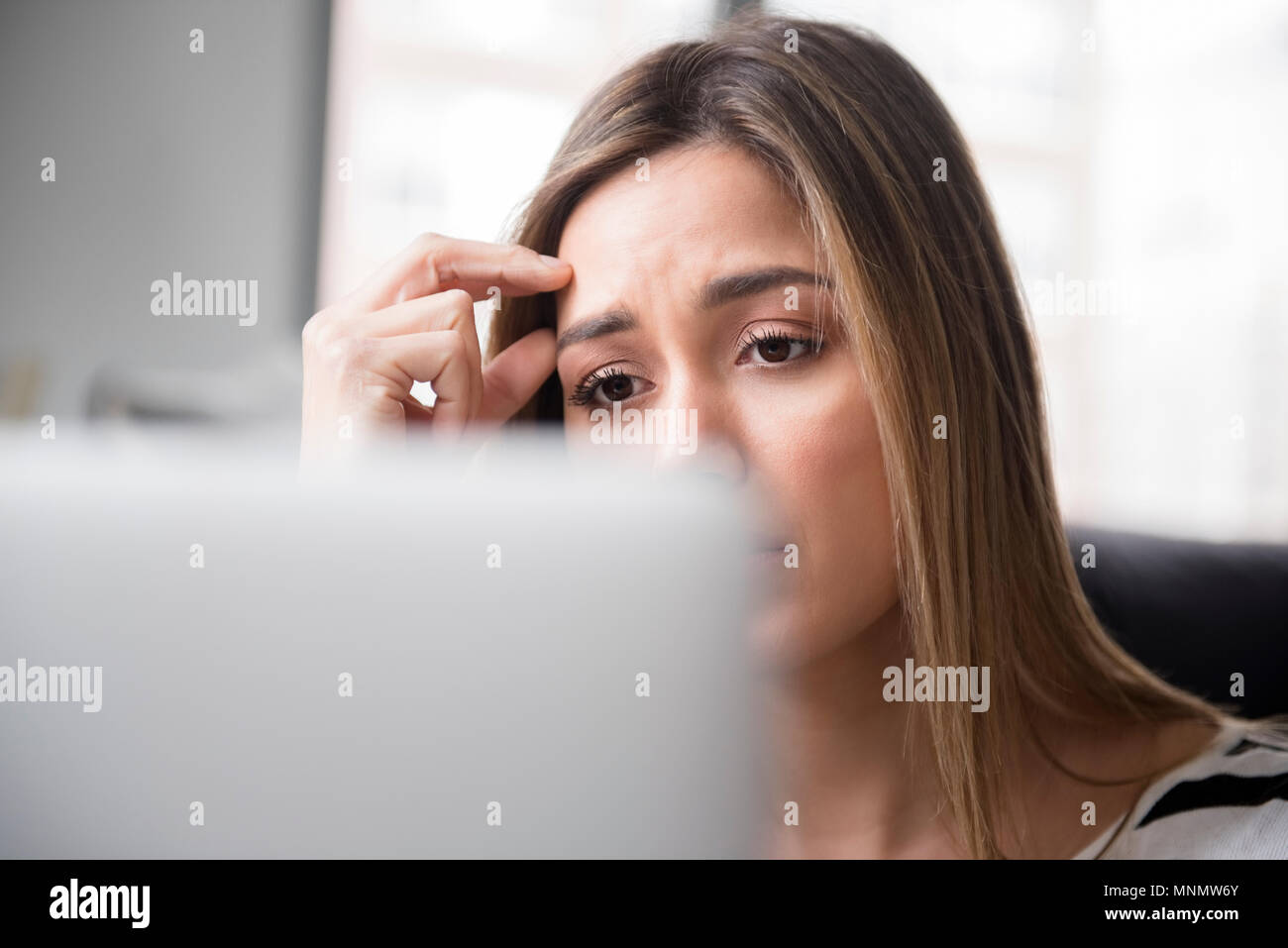 Inquiet jeune femme en face de l'ordinateur portable Banque D'Images