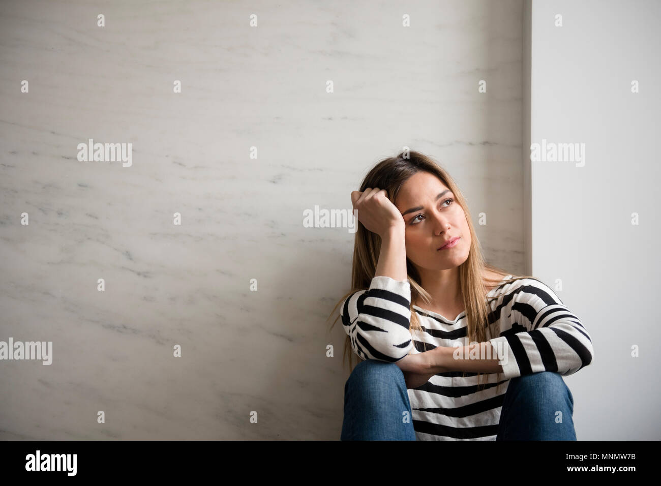 Jeune femme portant haut rayé daydreaming Banque D'Images Jeune femme portant haut rayé daydreaming Banque D'Images