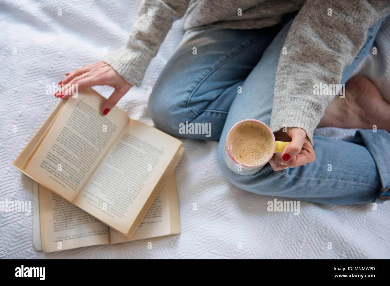 Femme au lit avec café et réservez Banque D'Images Femme au lit avec café et réservez Banque D'Images