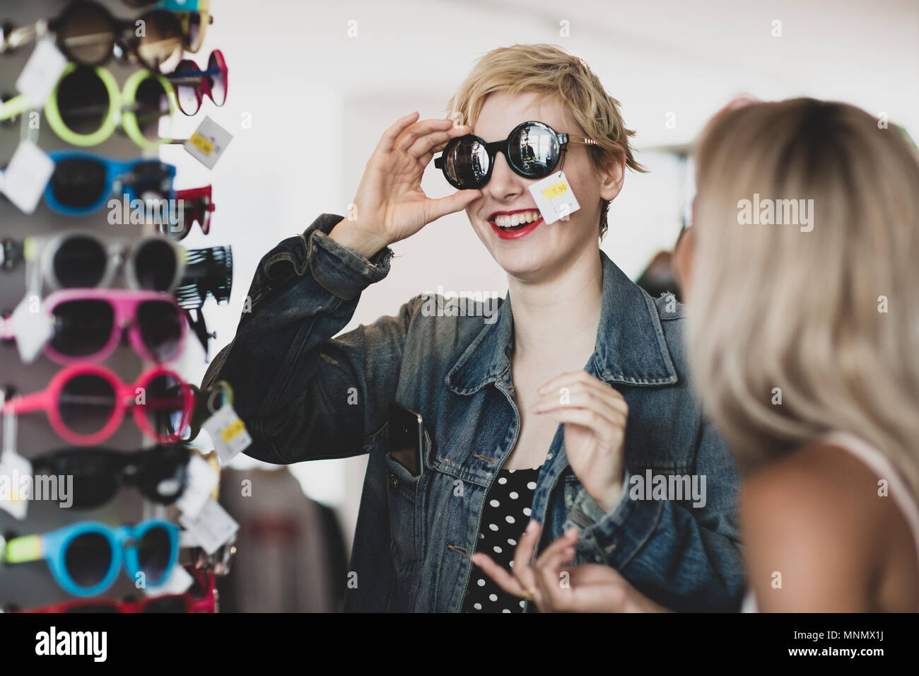La génération y essayer sur des lunettes de soleil dans un magasin vintage Banque D'Images