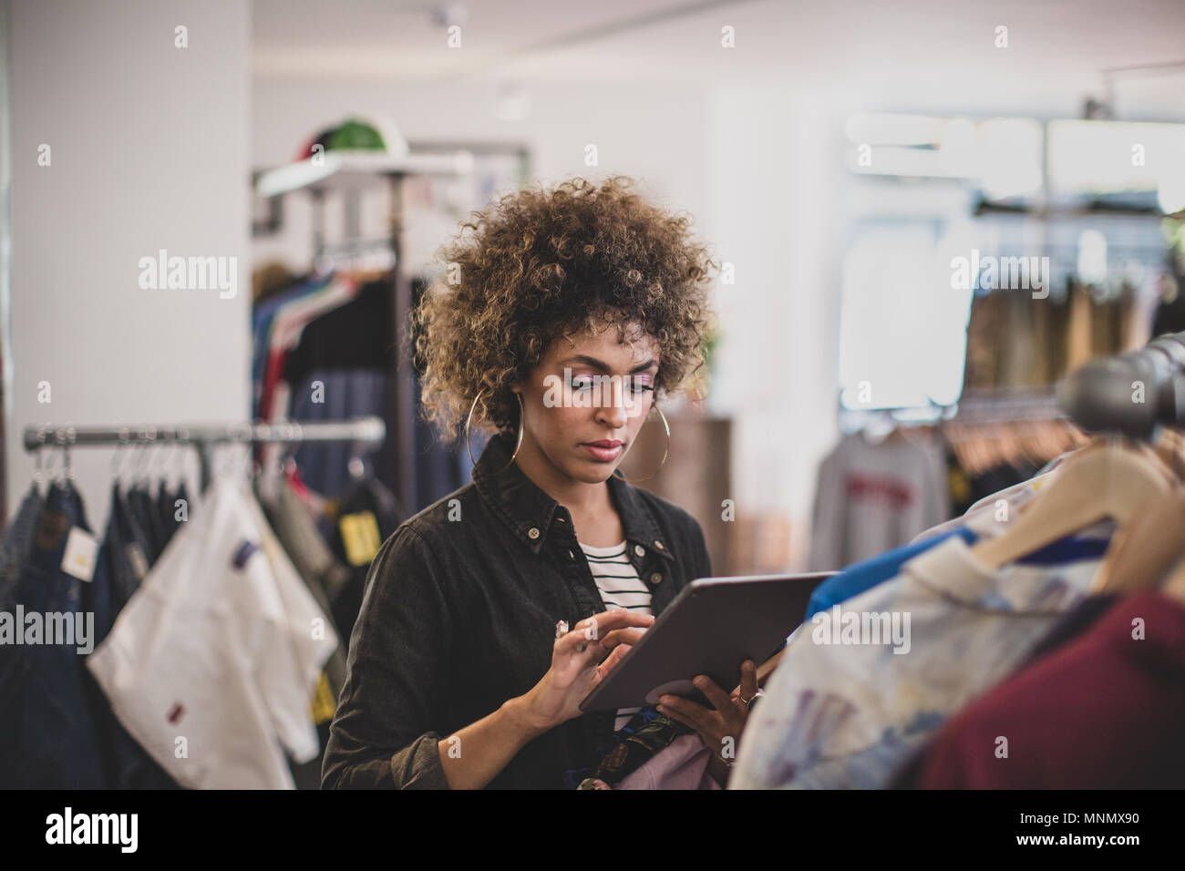 Store manager using digital tablet in a clothing store Banque D'Images