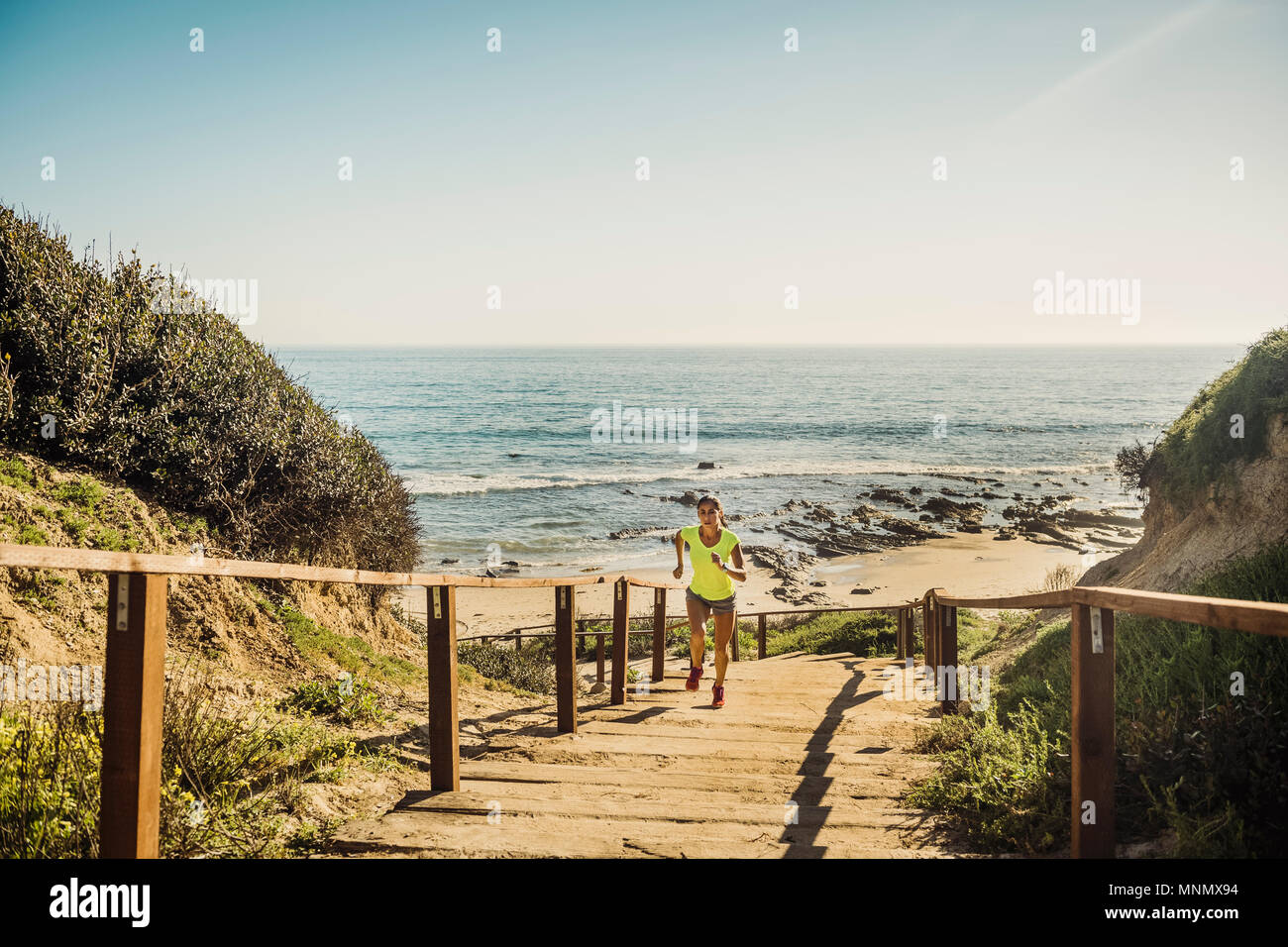 États-unis, Californie, Newport Beach, Woman running up stairs Banque D'Images