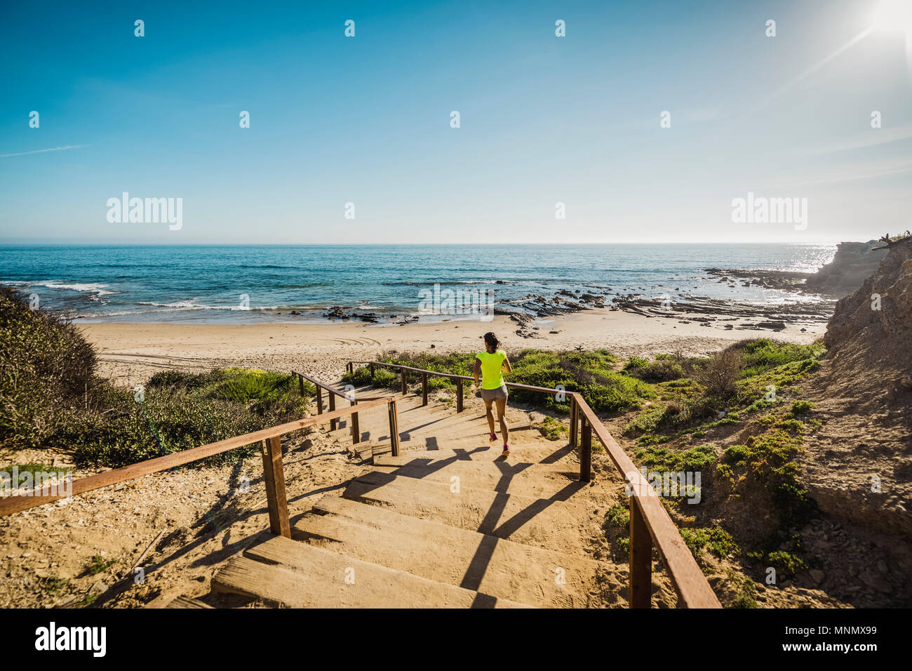 États-unis, Californie, Newport Beach, Woman running dans les escaliers Banque D'Images