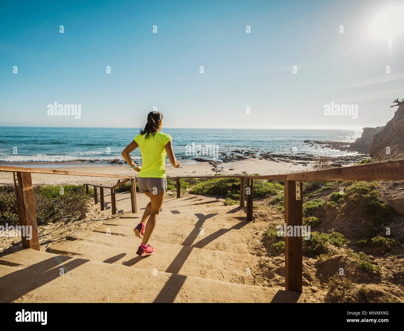États-unis, Californie, Newport Beach, Woman running dans les escaliers Banque D'Images