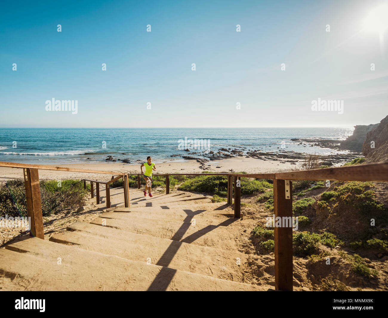 États-unis, Californie, Newport Beach, Woman running up stairs Banque D'Images