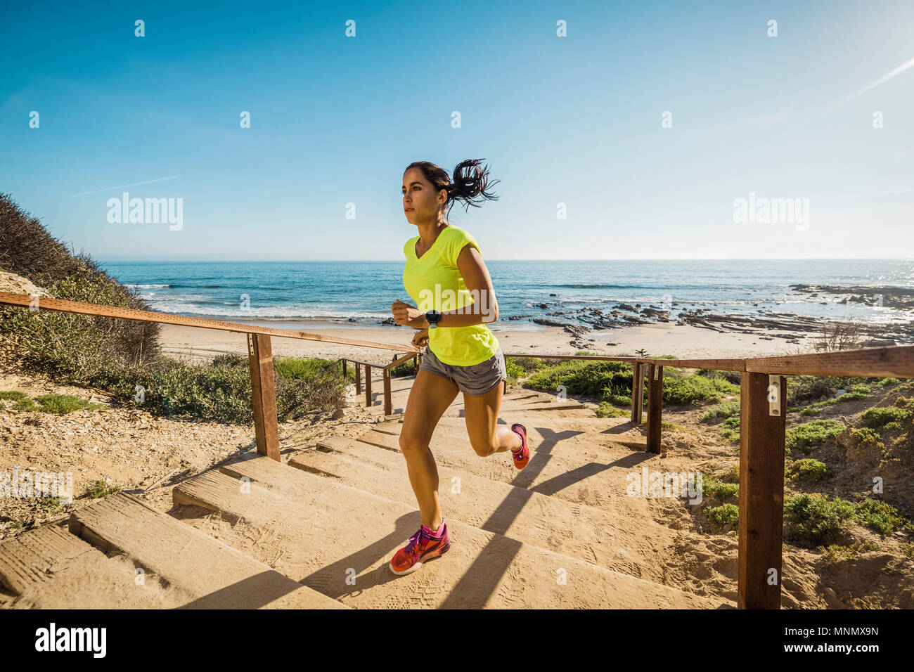 États-unis, Californie, Newport Beach, Woman running up stairs Banque D'Images