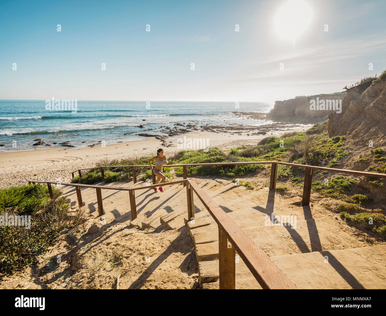 États-unis, Californie, Newport Beach, Woman running up stairs Banque D'Images