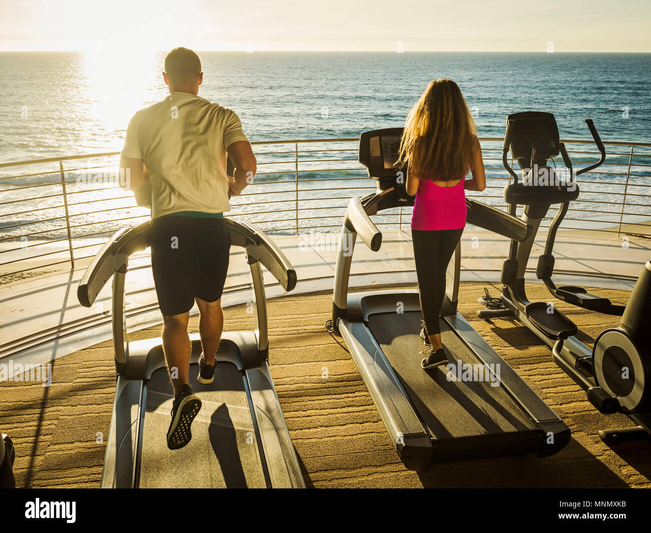 L'homme et la femme exerçant sur patio over sea Banque D'Images