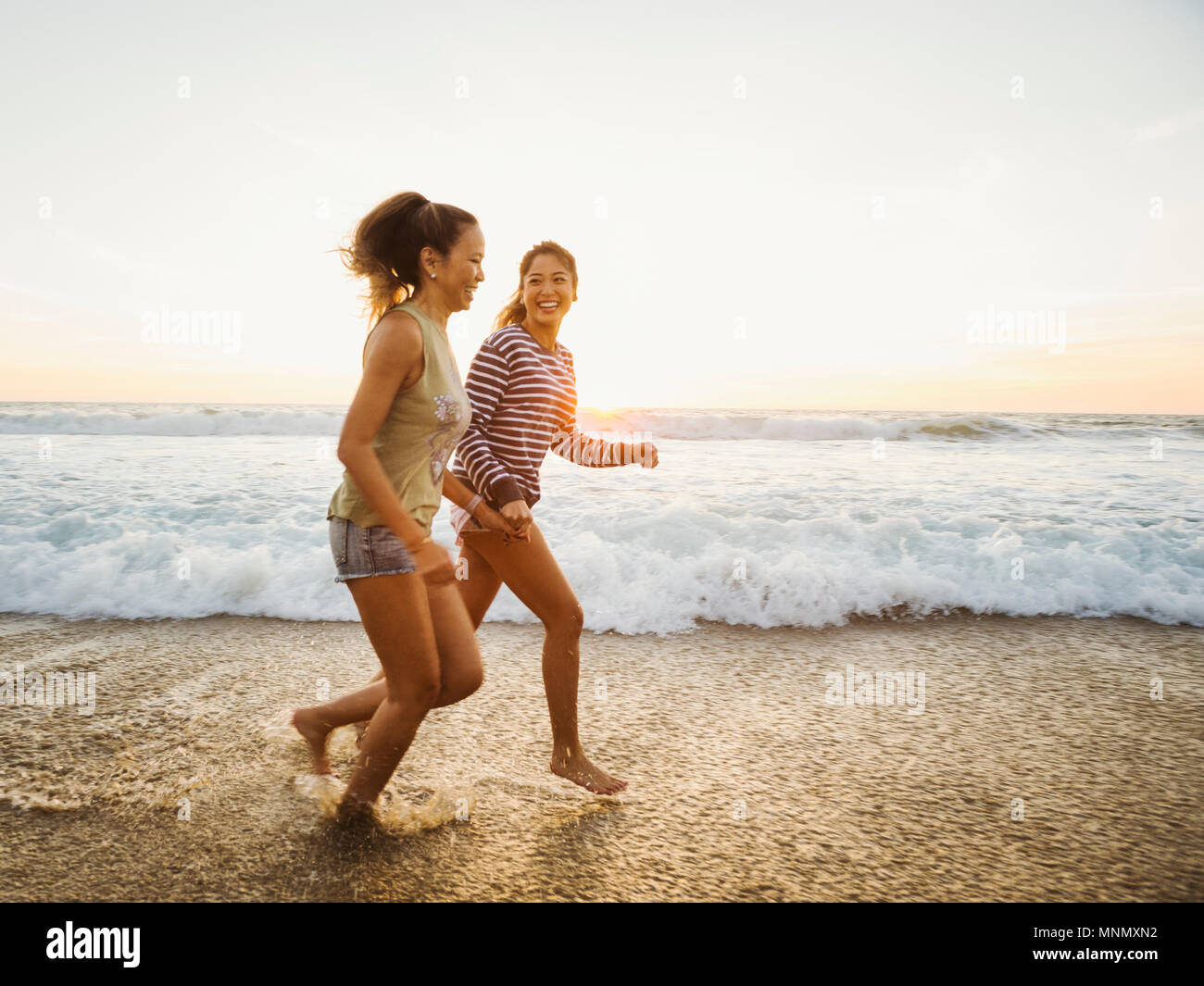 Mère et fille du jogging le long beach Banque D'Images