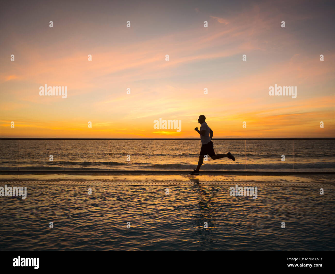 Man jogging le long de la piscine Banque D'Images