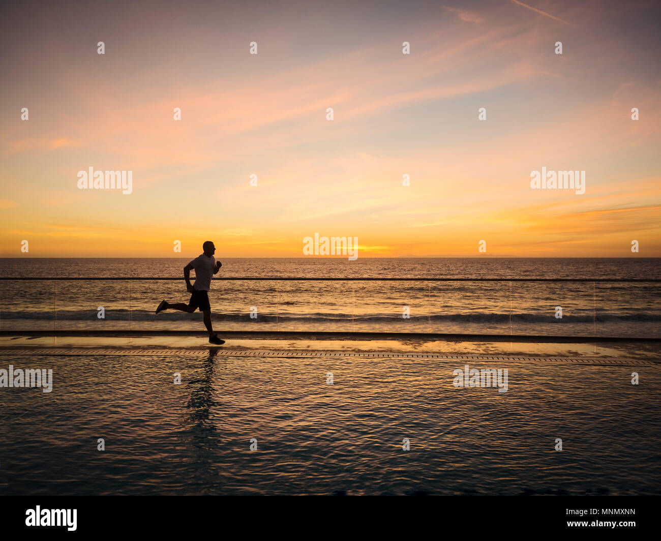Man jogging le long de la piscine Banque D'Images