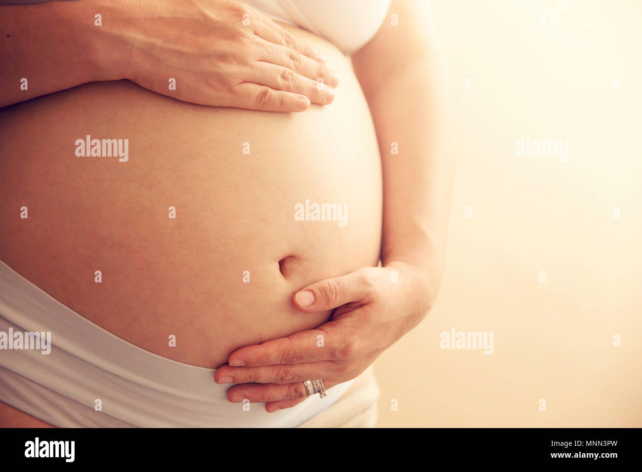 Jeune femme enceinte détient les mains sur son ventre. préparation et d'attente concept. close-up avec copie espace horizontal. Banque D'Images