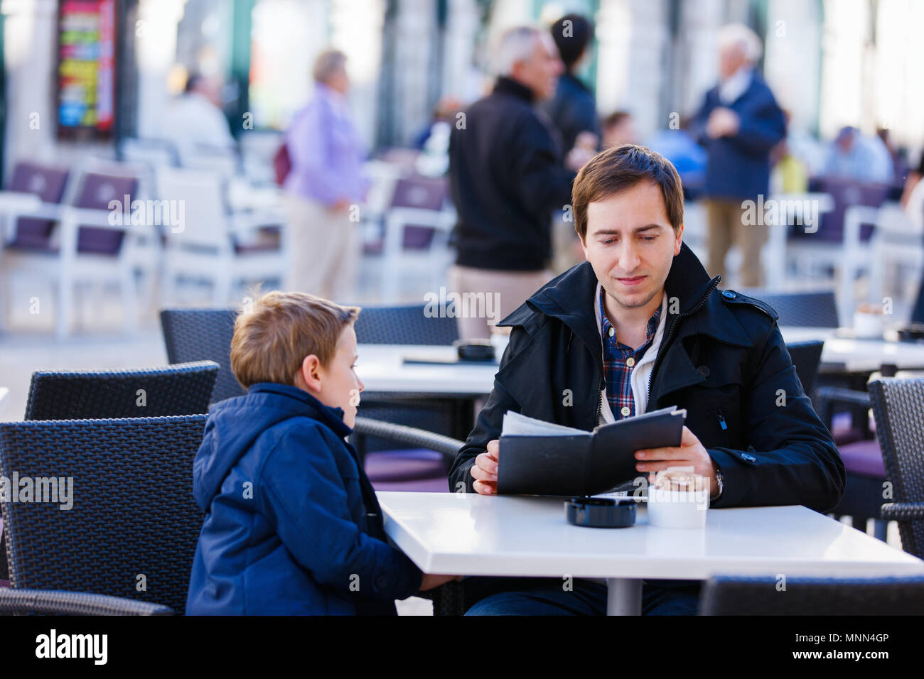 Jeune père et son fils au café en plein air sur la journée d'automne Banque D'Images