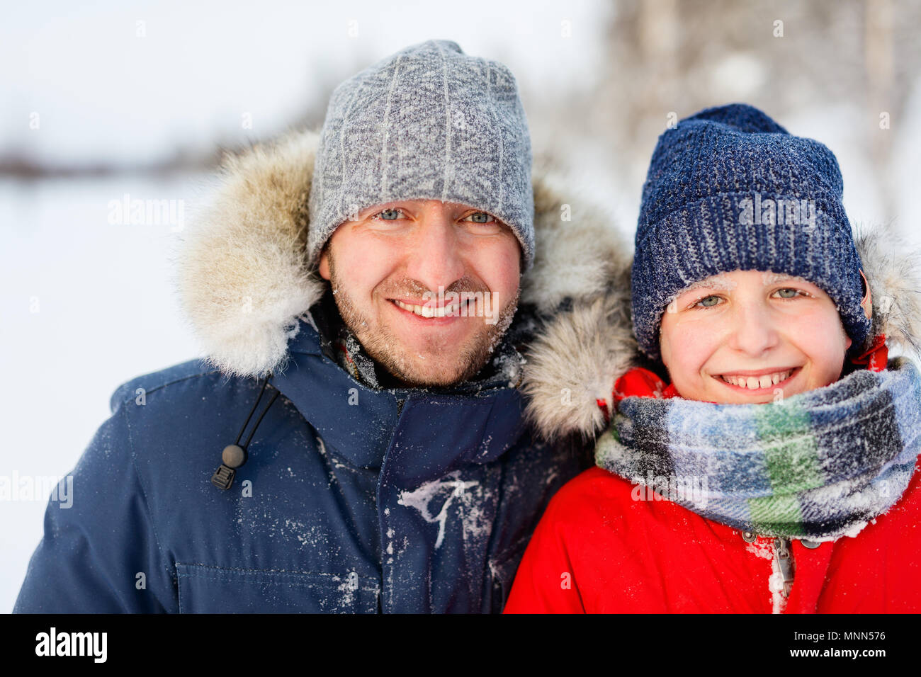Famille du père et son fils à l'extérieur sur la belle neige d'hiver Banque D'Images