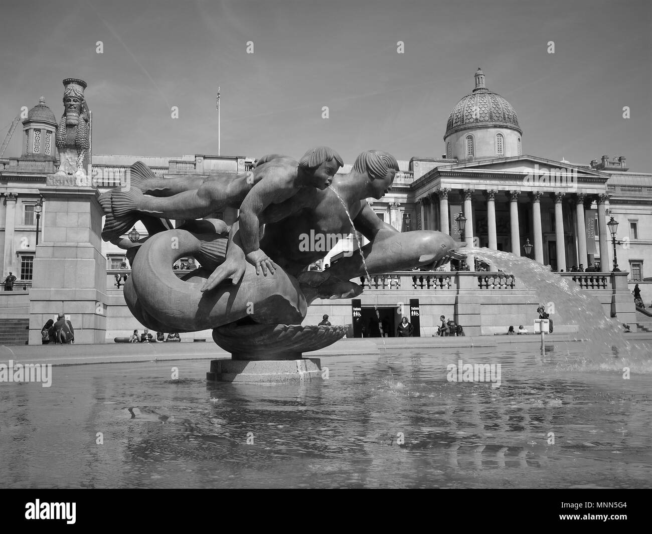 Londres - le 18 mai 2018 : ( Image modifiée numériquement à monochrome ) Fontaines de Trafalgar Square avec la célèbre Galerie Nationale derrière Banque D'Images