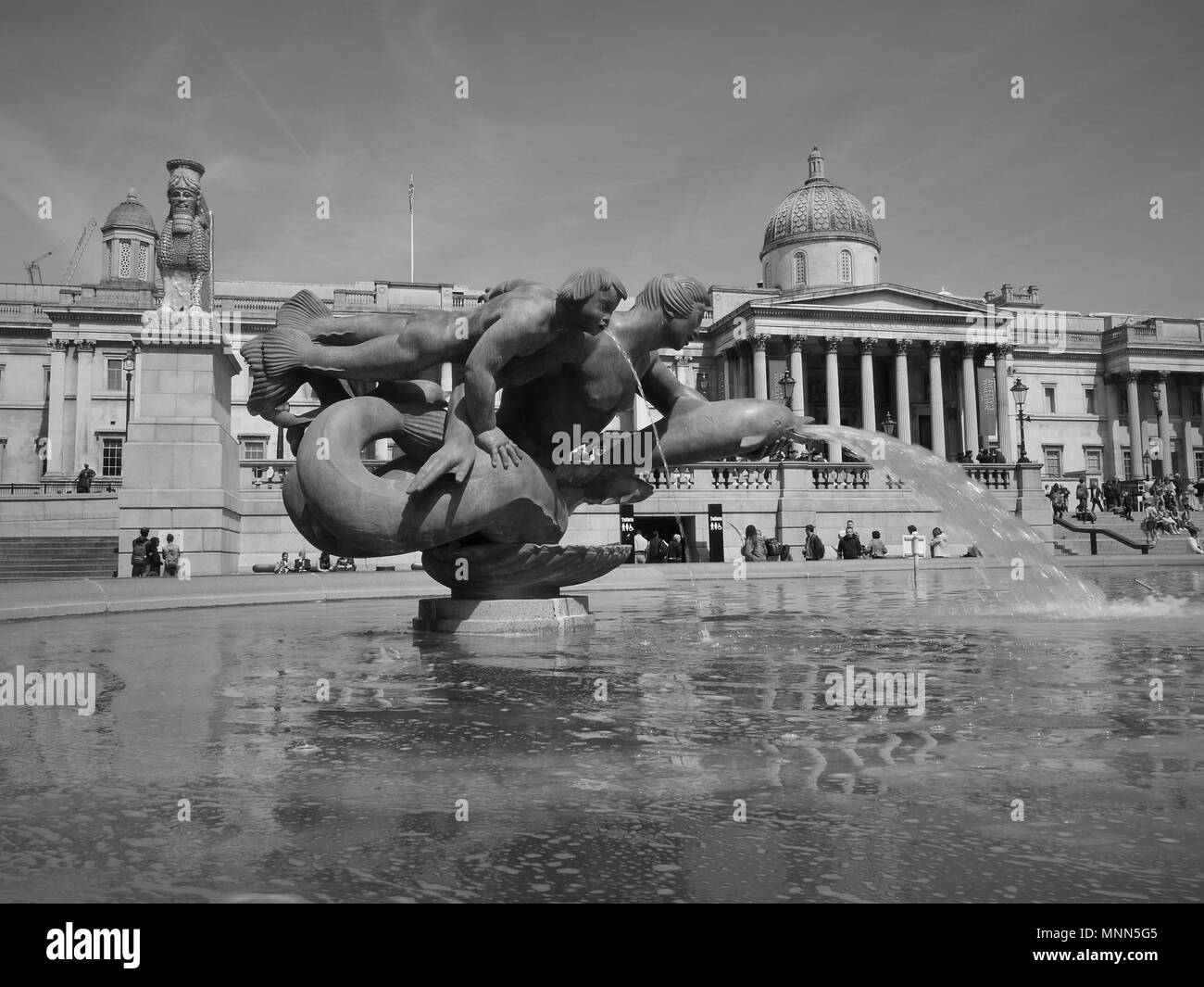 Londres - le 18 mai 2018 : ( Image modifiée numériquement à monochrome ) Fontaines de Trafalgar Square avec la célèbre Galerie Nationale derrière Banque D'Images