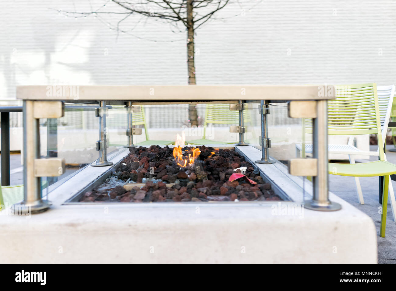 Dans le feu, à l'extérieur du parc avec orange rouge flamme, personne, des chaises modernes en hiver, charbon, déchets pour réchauffer les mains sur journée froide Banque D'Images