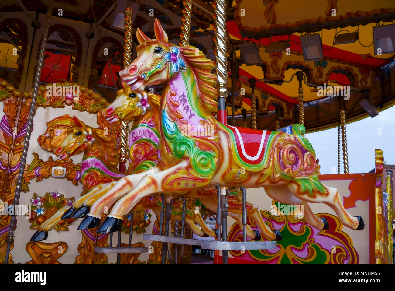 Chevaux sur un champ de foire carousel ride Banque D'Images