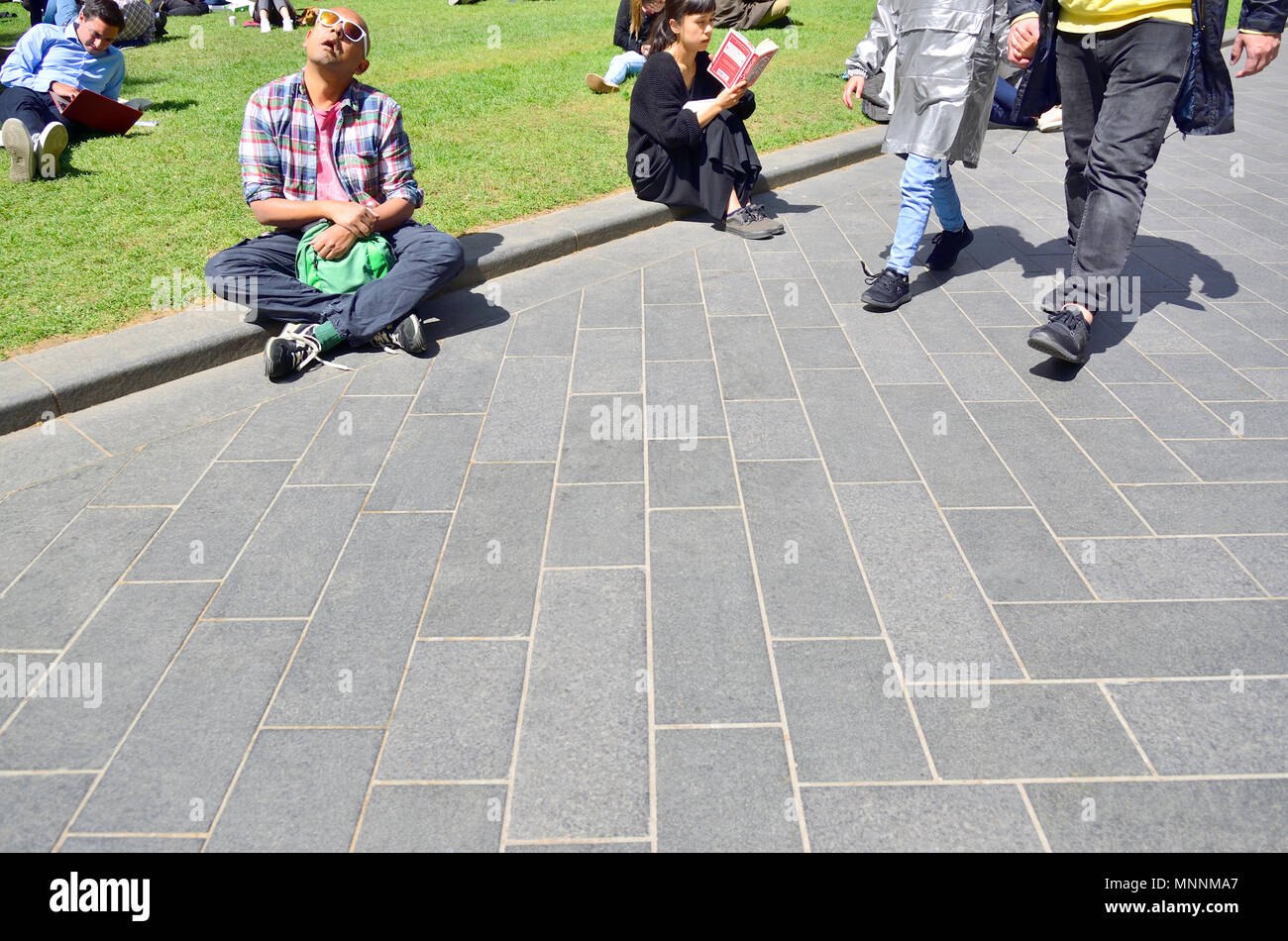 Les gens se détendre au soleil, le centre de Londres, Angleterre, Royaume-Uni. Banque D'Images