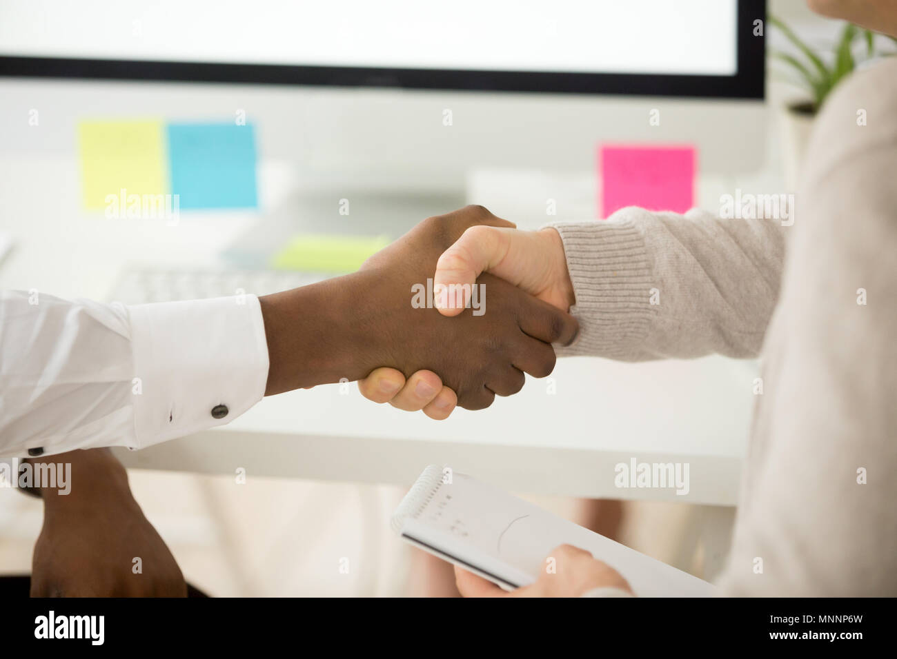Poignée de multiraciale comme concept d'aide support à plateau Banque D'Images