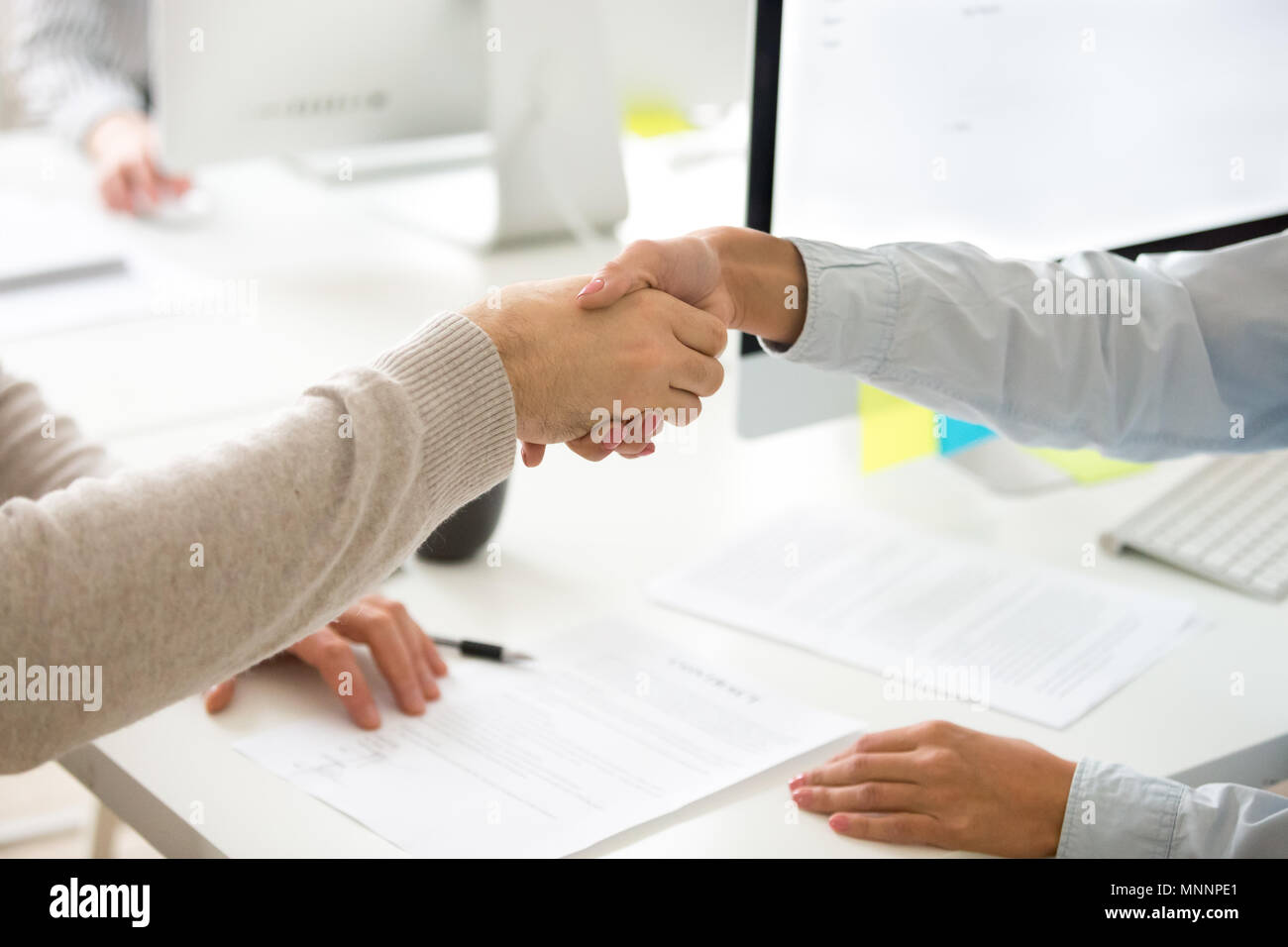 Poignée de main de l'homme et de la femme après la signature du contrat d'entreprise, clos Banque D'Images