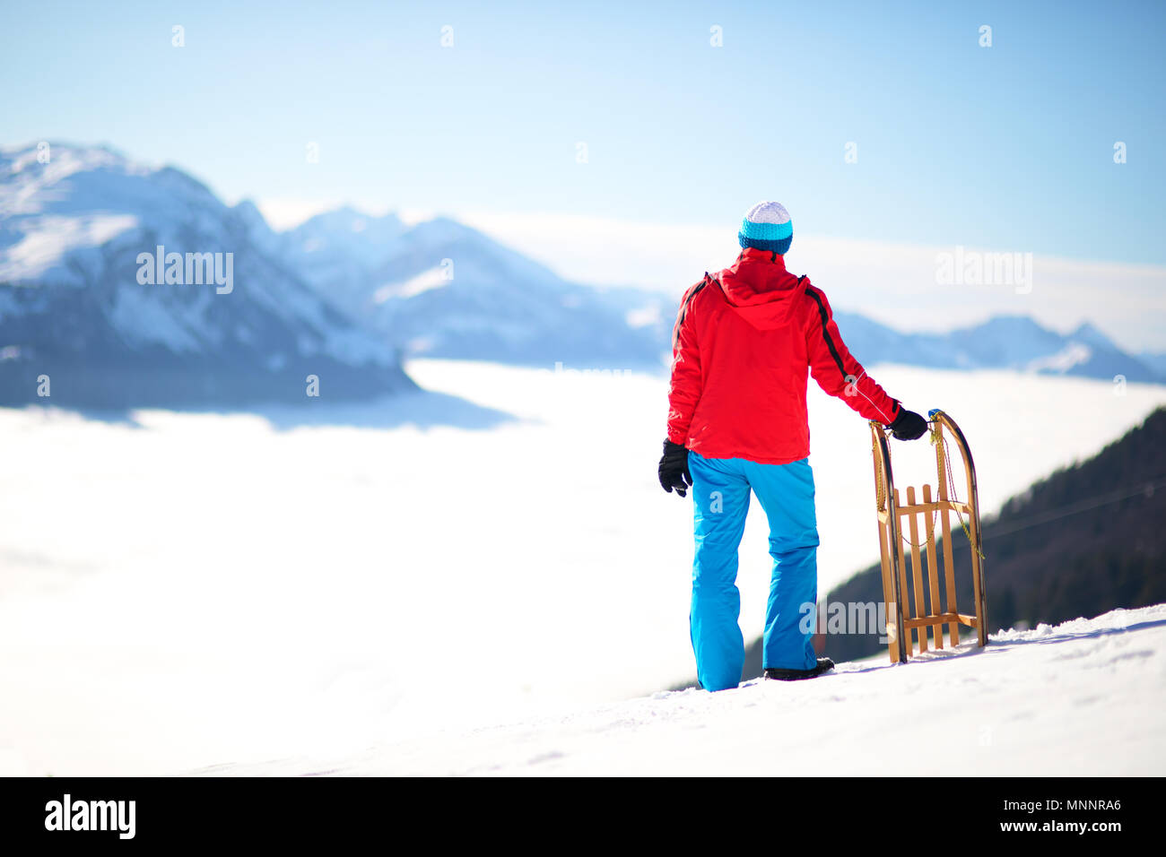 Jeune homme séduisant prêt à partir de traîneau à Alpes Suisses au cours de l'hiver vacances. Banque D'Images