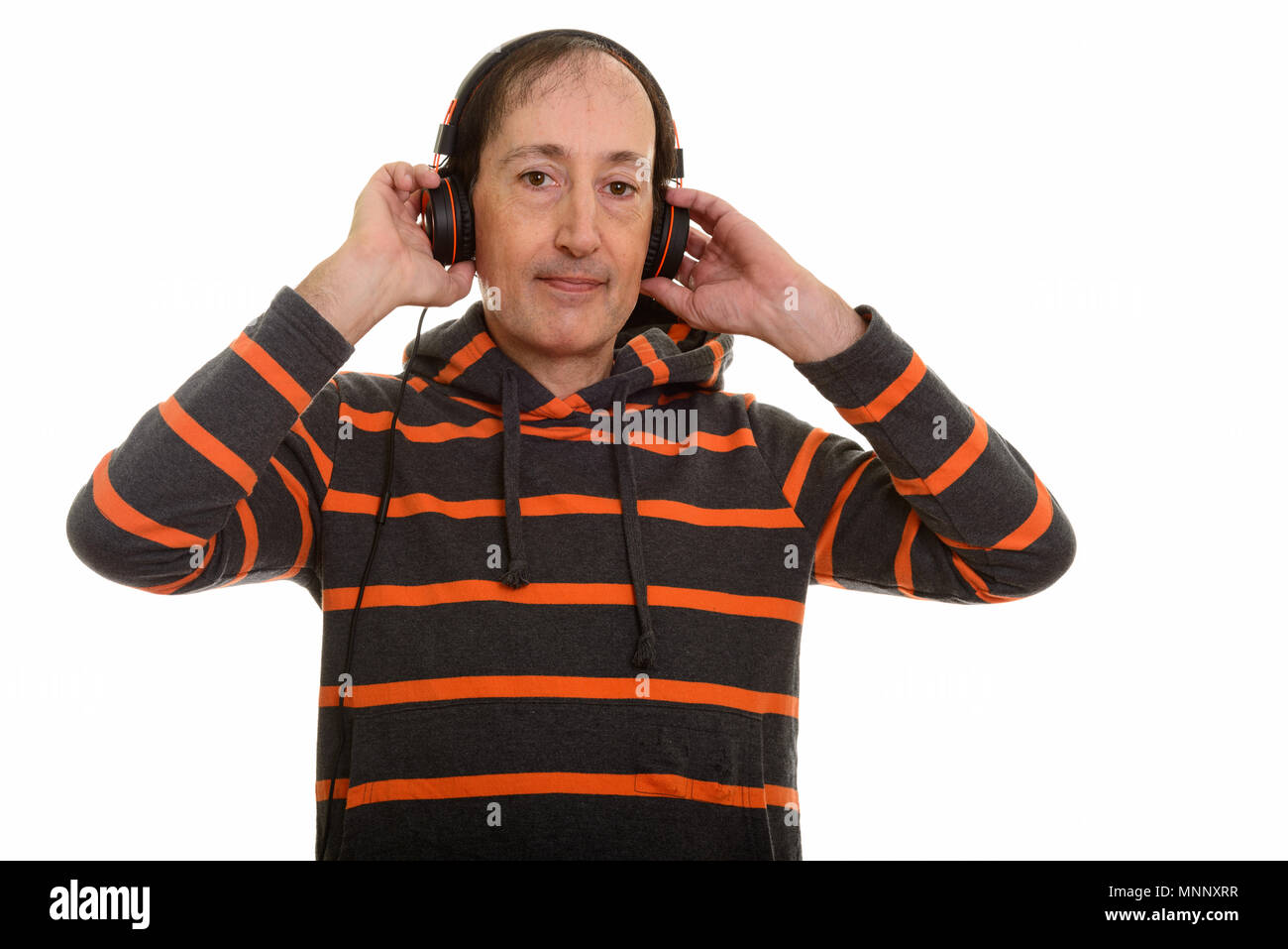 Studio shot of mature man holding pendant l'écoute d'un casque Banque D'Images