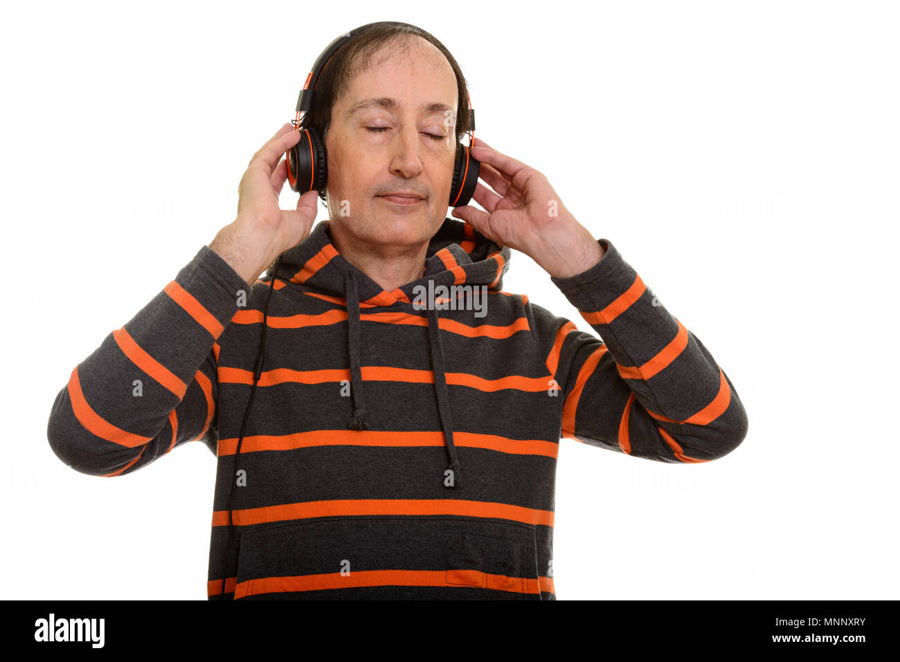 Studio shot of mature man écouter de la musique avec les yeux fermé Banque D'Images