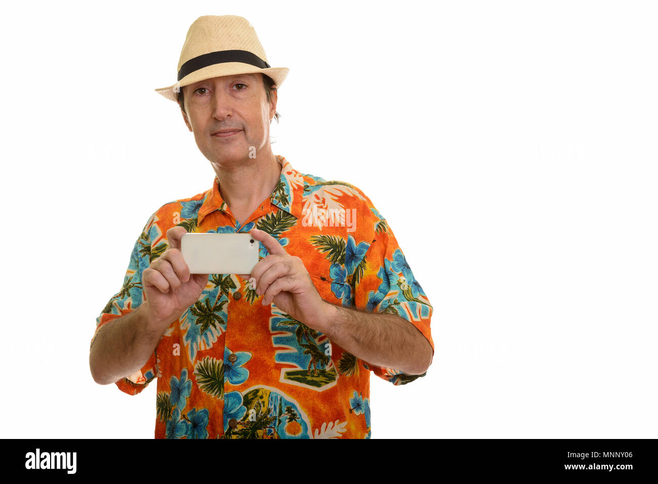 Studio shot of mature man taking picture with mobile phone Banque D'Images
