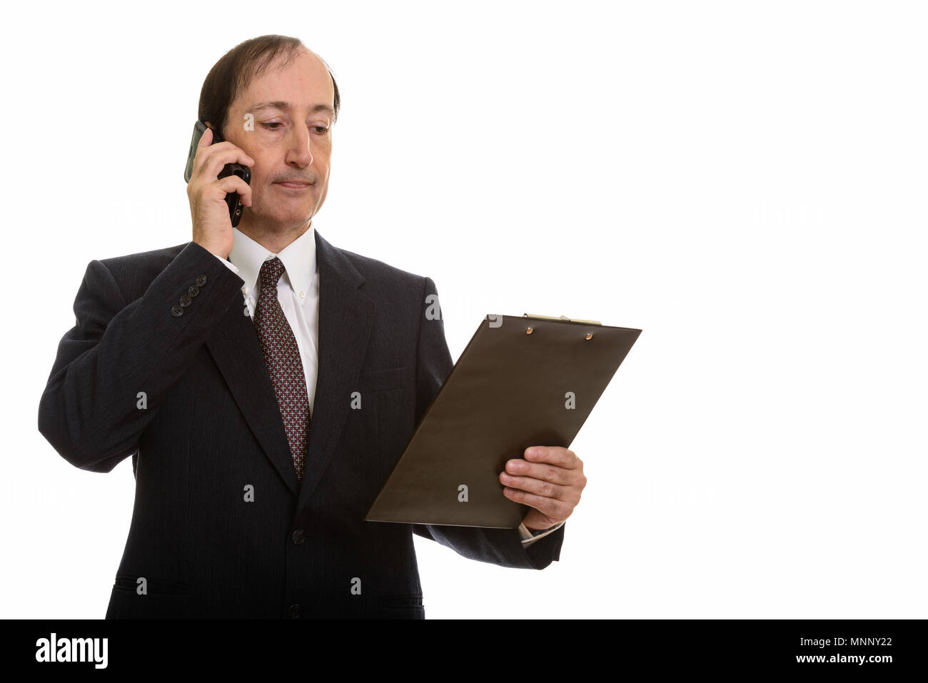 Studio shot of businessman talking on mobile phone while Banque D'Images