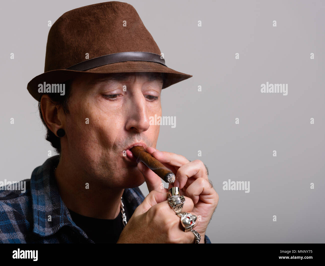Studio shot of mature gangster homme cigare d'éclairage Banque D'Images