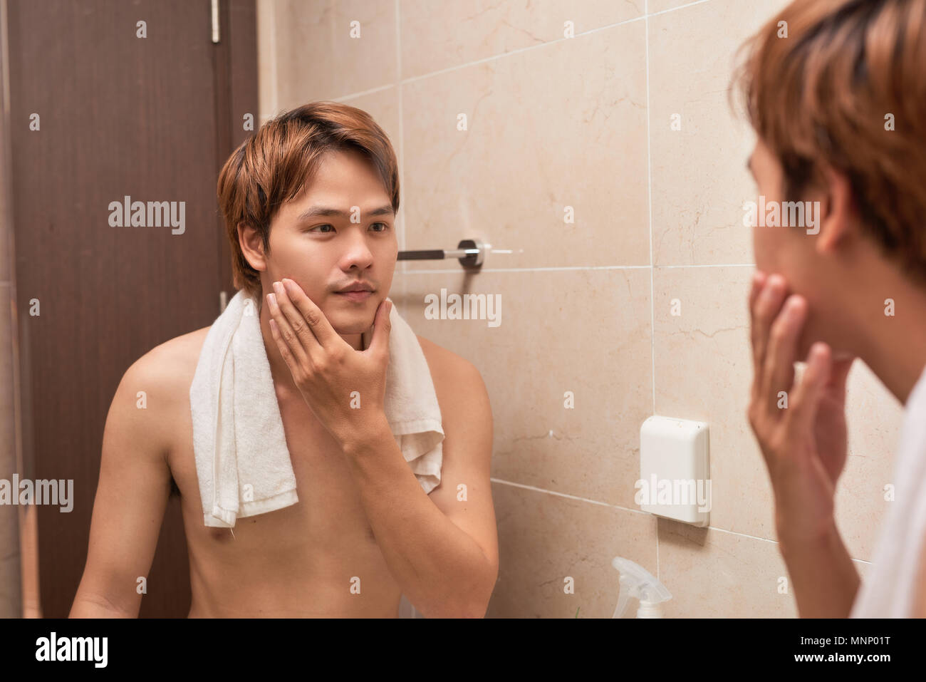 La beauté masculine. Beau jeune homme asiatique, sur sa face lisse après le rasage Banque D'Images