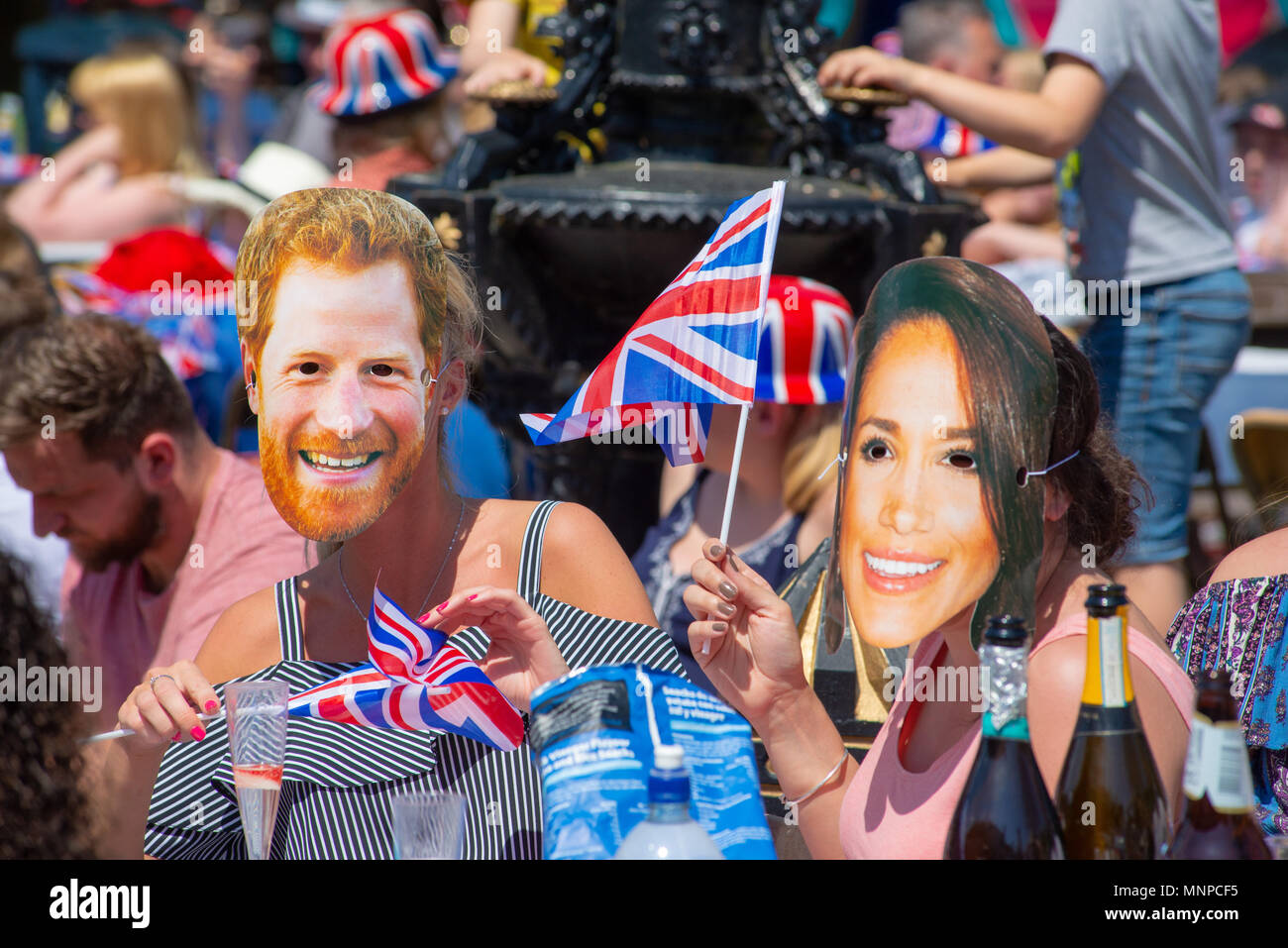 Des gens portant des masques de Prince Harry et Meghan Markle et des drapeaux d'Union Jack à une fête de rue pour observer et célébrer le mariage royal. Ringwood, Hampshire, Angleterre, Royaume-Uni, 19th mai 2018. Banque D'Images