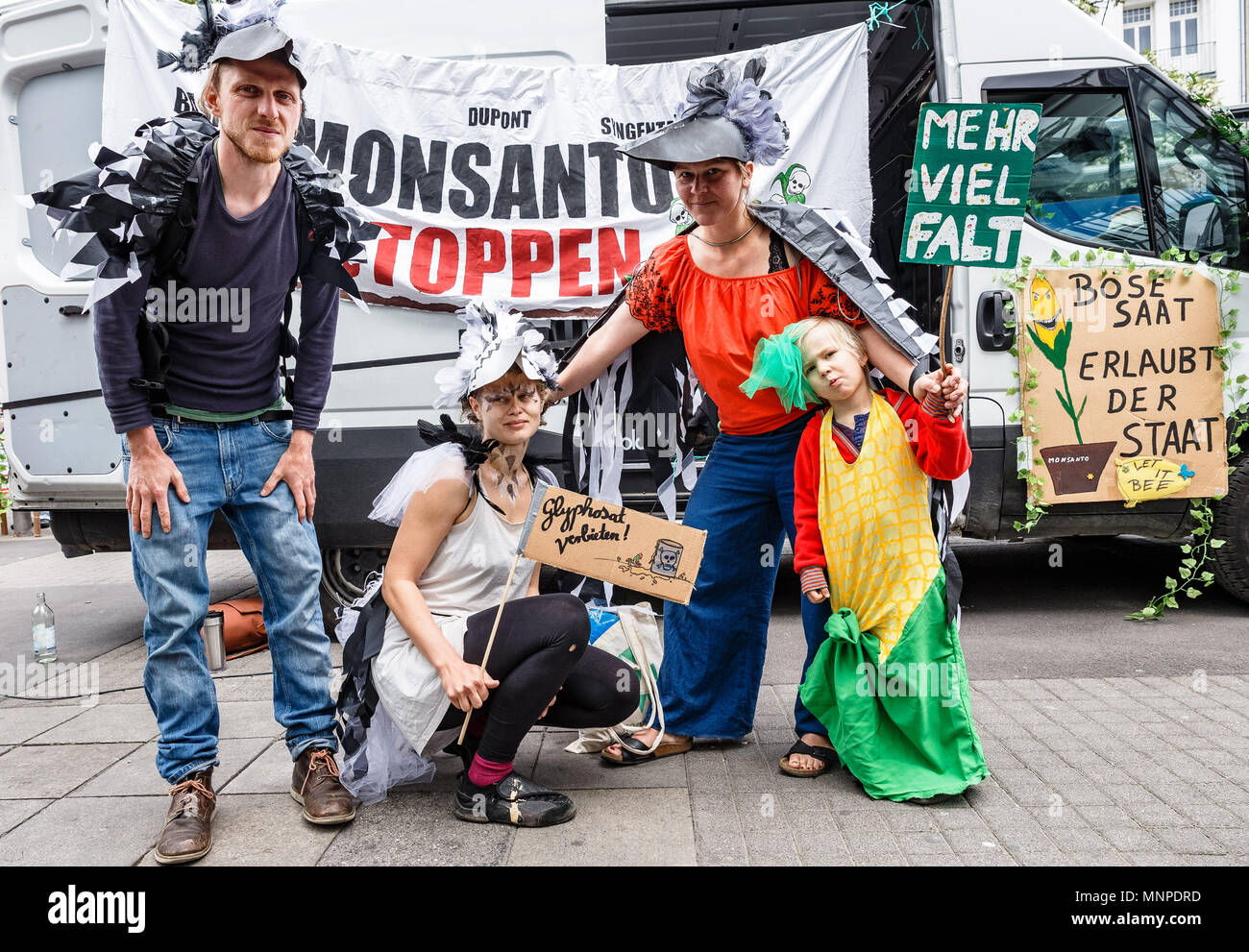 19 mai 2018, l'Allemagne, Hambourg : manifestants déguisés en oiseaux se tenir en face d'une lecture 'Monsanto benner stoppen' (lit. stop Monsanto) sur la campagne mondiale contre le jour coroporation agricole Monsanto. Ils manifester contre les semences génétiquement modifiées et, selon leur opinion, les pesticides qui sont nocifs pour l'environnement. Photo : Markus Scholz/dpa Banque D'Images