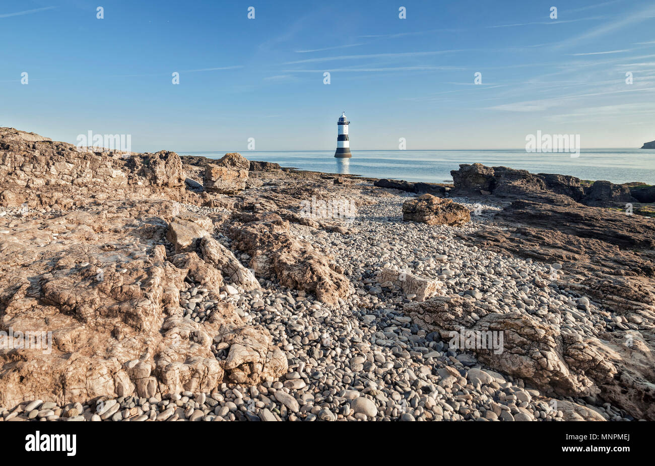 Penmon Point Lighthouse et érodé shore cliff à bright matin ensoleillé. L'île d'Anglesey dans le Nord du Pays de Galles, Royaume-Uni Banque D'Images