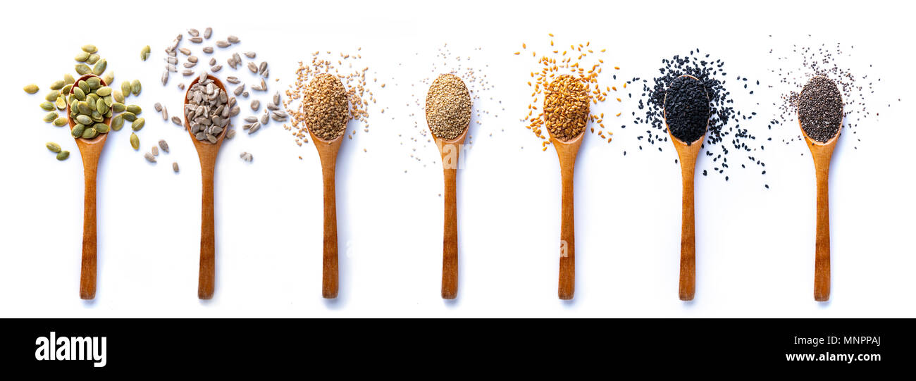 Mise à plat des cuillères en bois avec diverses graines saines en mix sur fond blanc. Banque D'Images