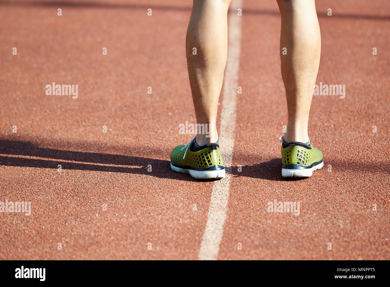 Close-up de jambes d'un athlète masculin debout sur la voie. Banque D'Images