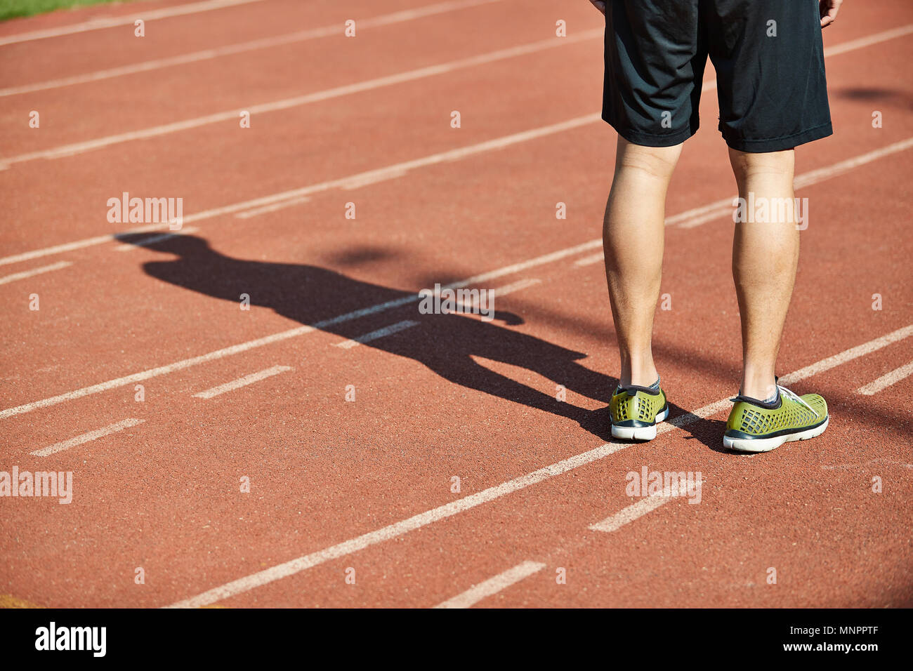 Close-up de jambes d'un athlète masculin debout sur la voie. Banque D'Images