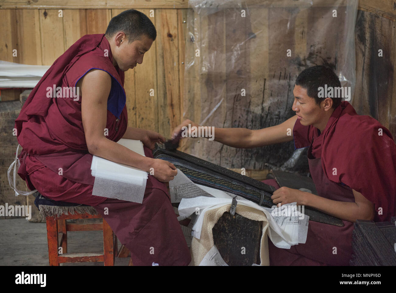 Des moines et écritures papier fait main à l'intérieur de gravures la sainte Ecriture Imprimerie Bakong monastère à Dege, Sichuan, Chine Banque D'Images