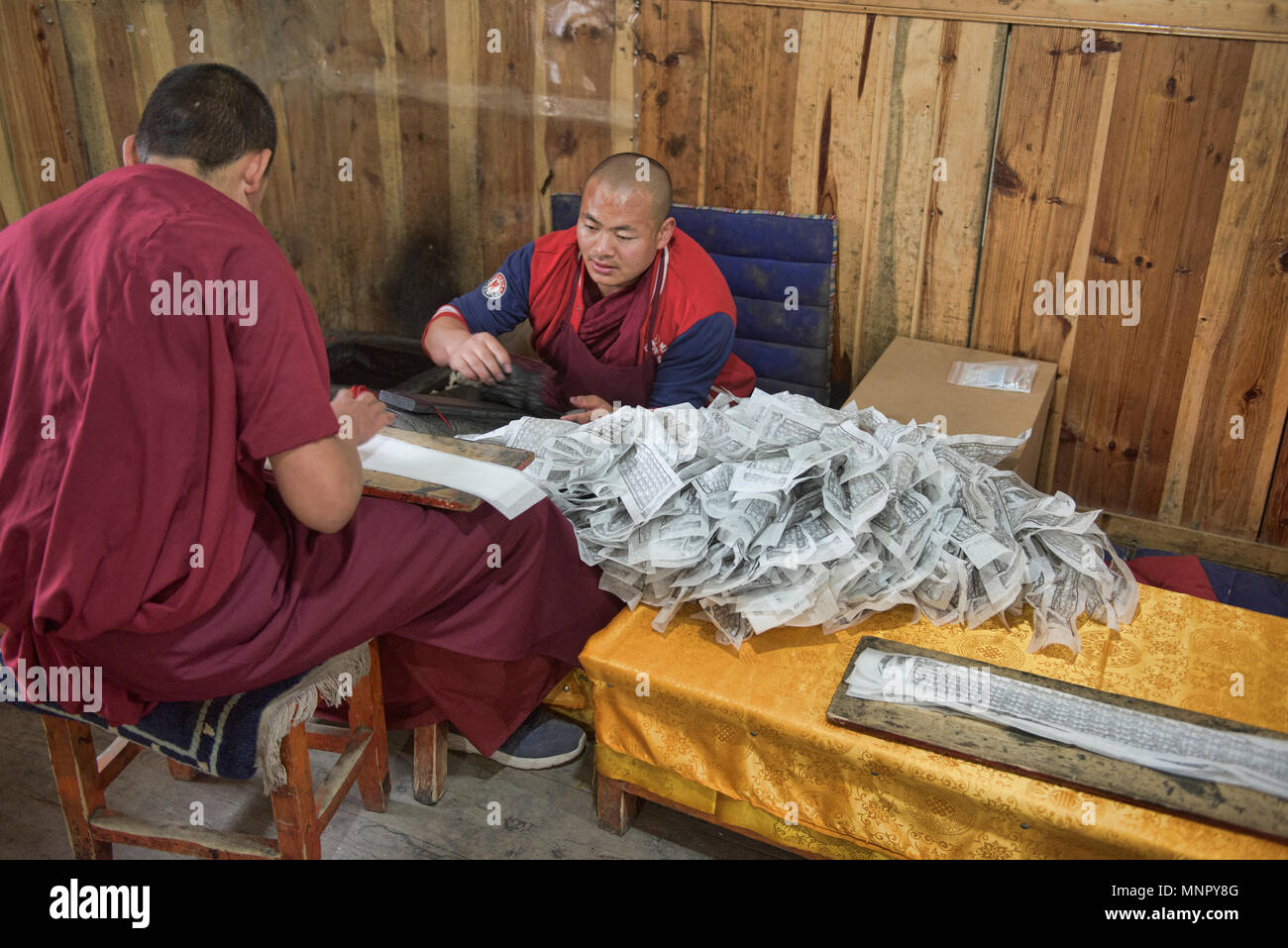 Des moines et écritures papier fait main à l'intérieur de gravures la sainte Ecriture Imprimerie Bakong monastère à Dege, Sichuan, Chine Banque D'Images